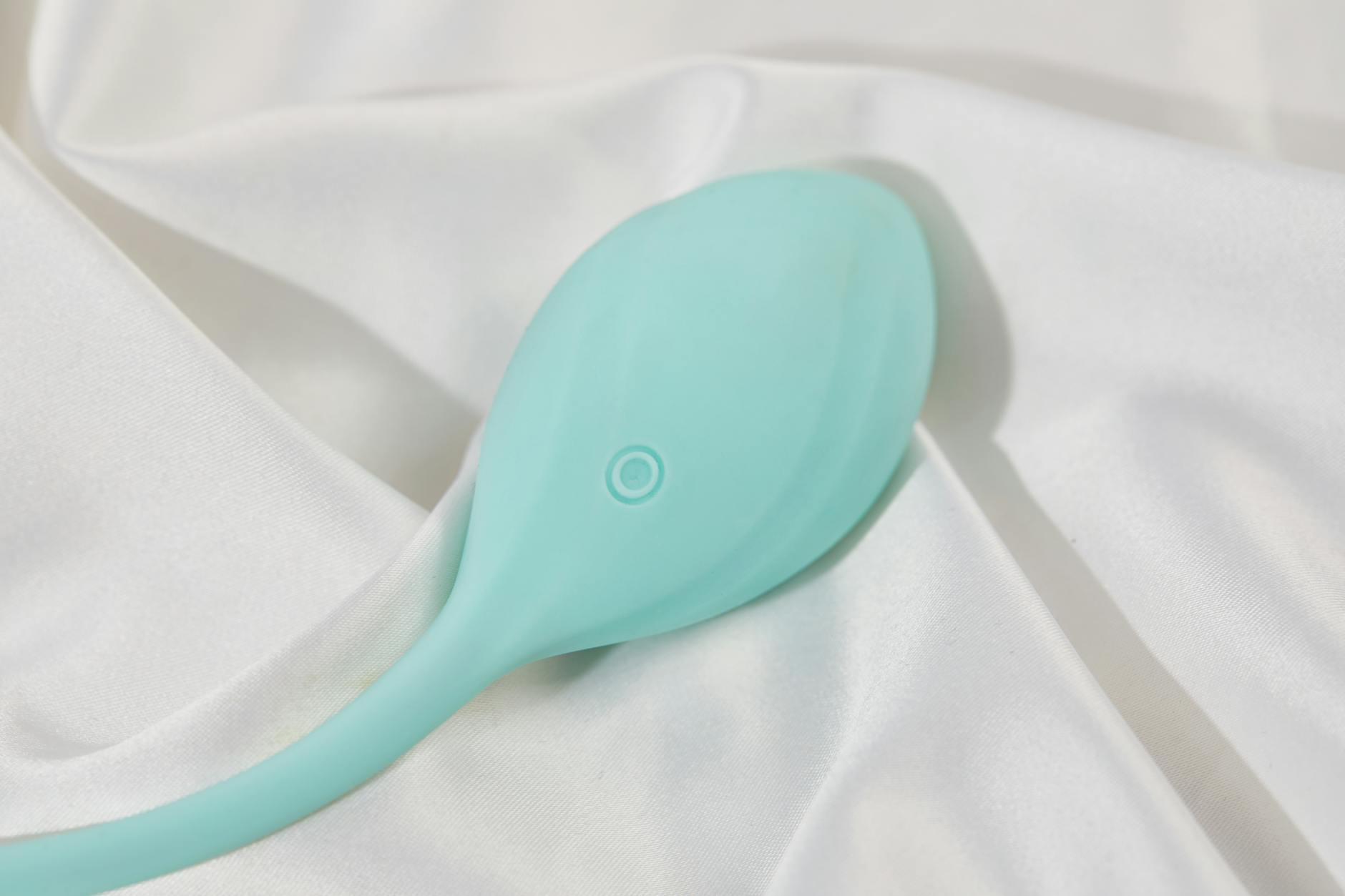 Ein stilvoller Zitronenvibrator auf glatter weißer Seide