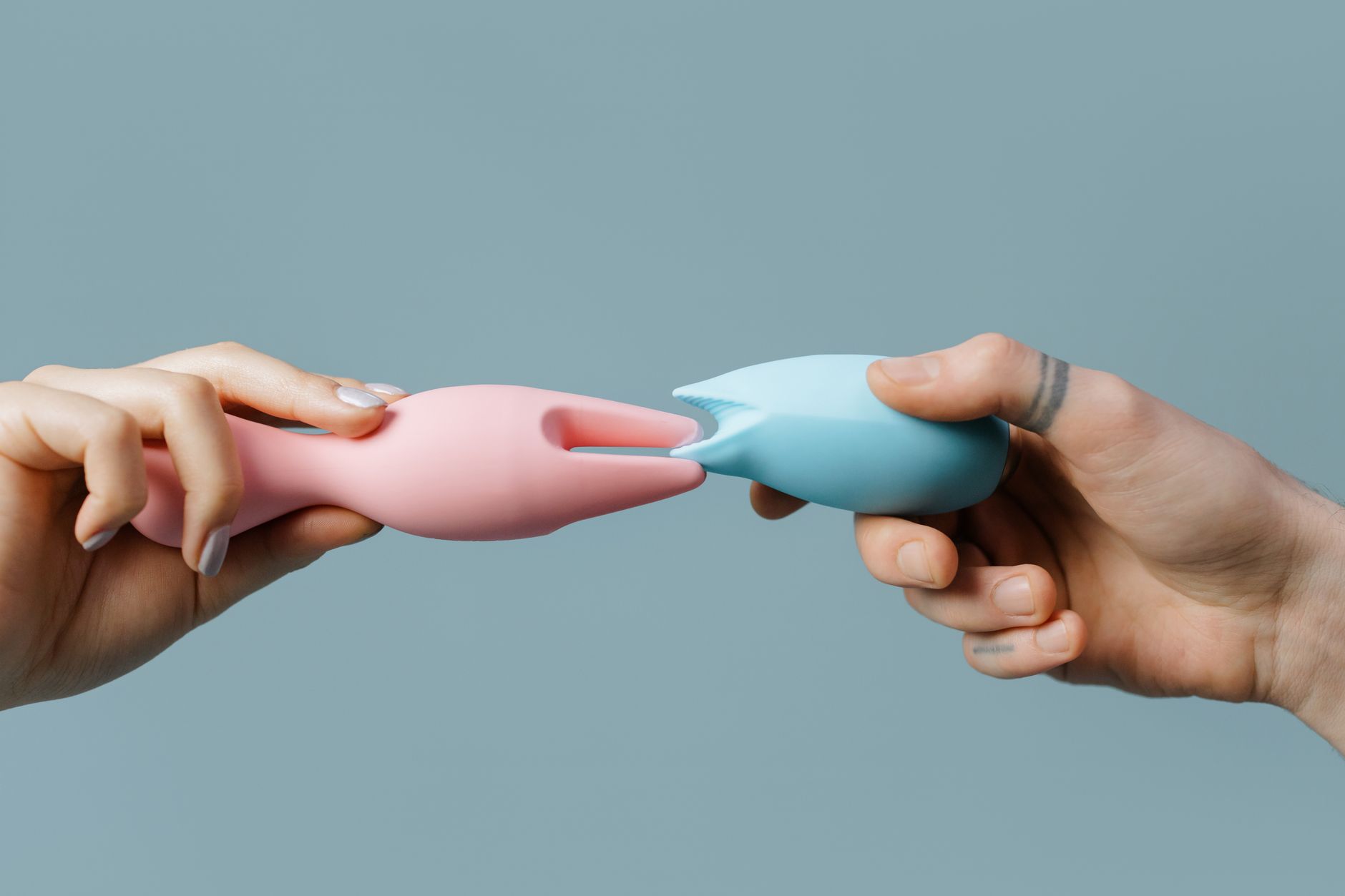 Close-up of hands holding a sleek blue vibrator, symbolizing intimate reconnection